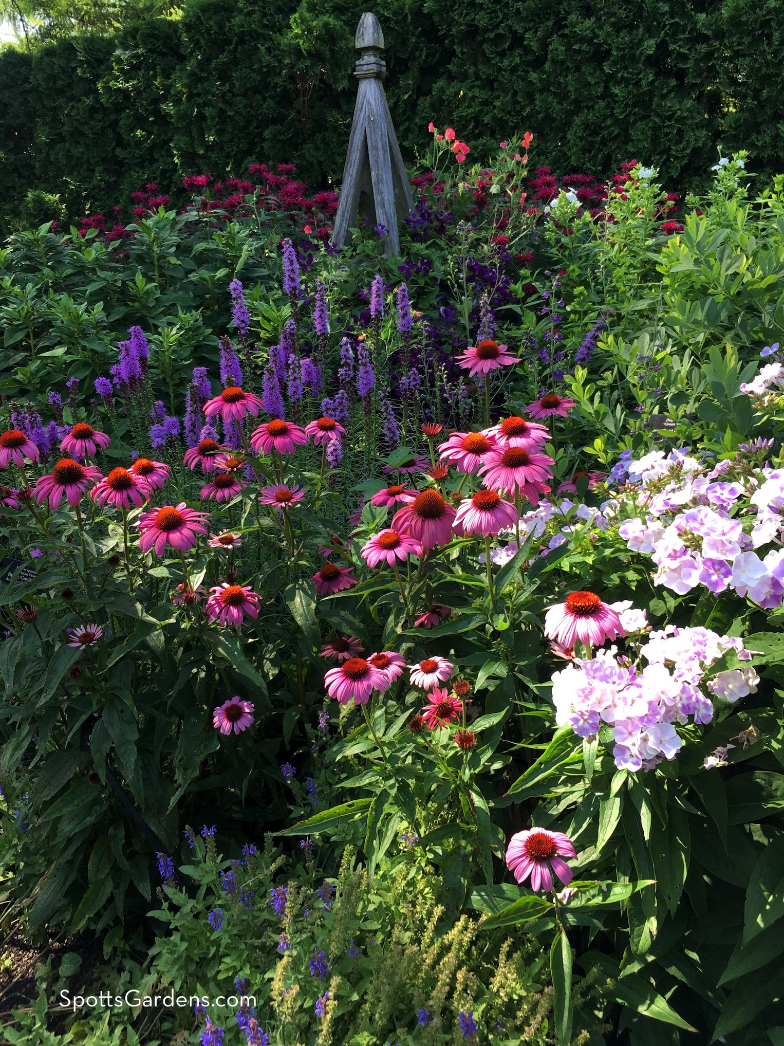 Wooden garden tuteur with blooming flowers